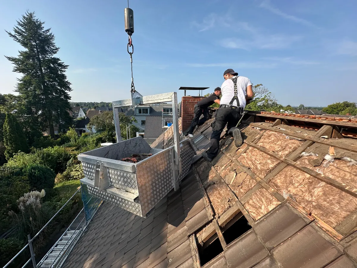 Dachdecker bei Sanierungsarbeiten auf einem Steildach.